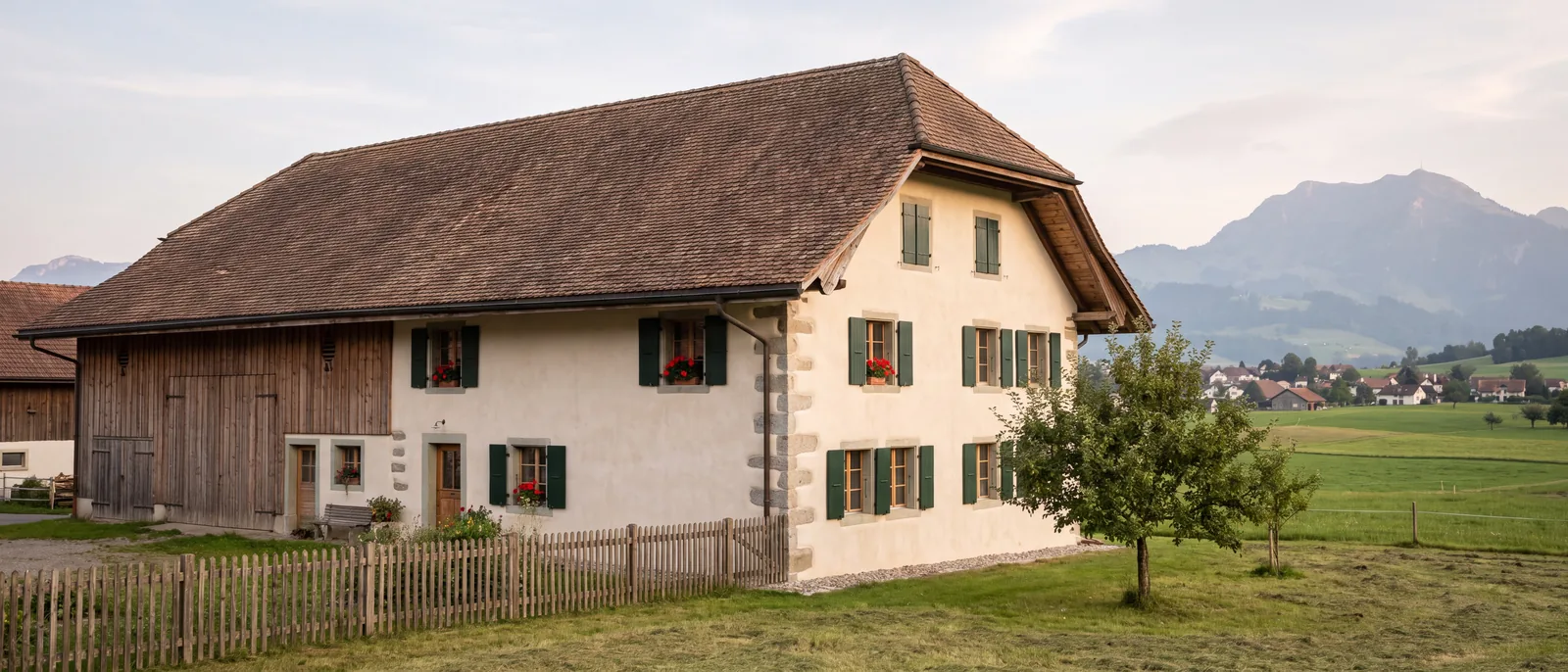 Maison traditionnelle de la Gruyère à la façade fraîchement rénovée, au pied des Préalpes